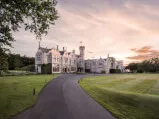 SCHLOSS Roxburghe, ein großes Steingebäude mit einem üppigen Rasen und einer Straße, Teil der Destination by Hyatt.