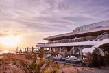 A serene beachside building with a beautiful sunset in the background