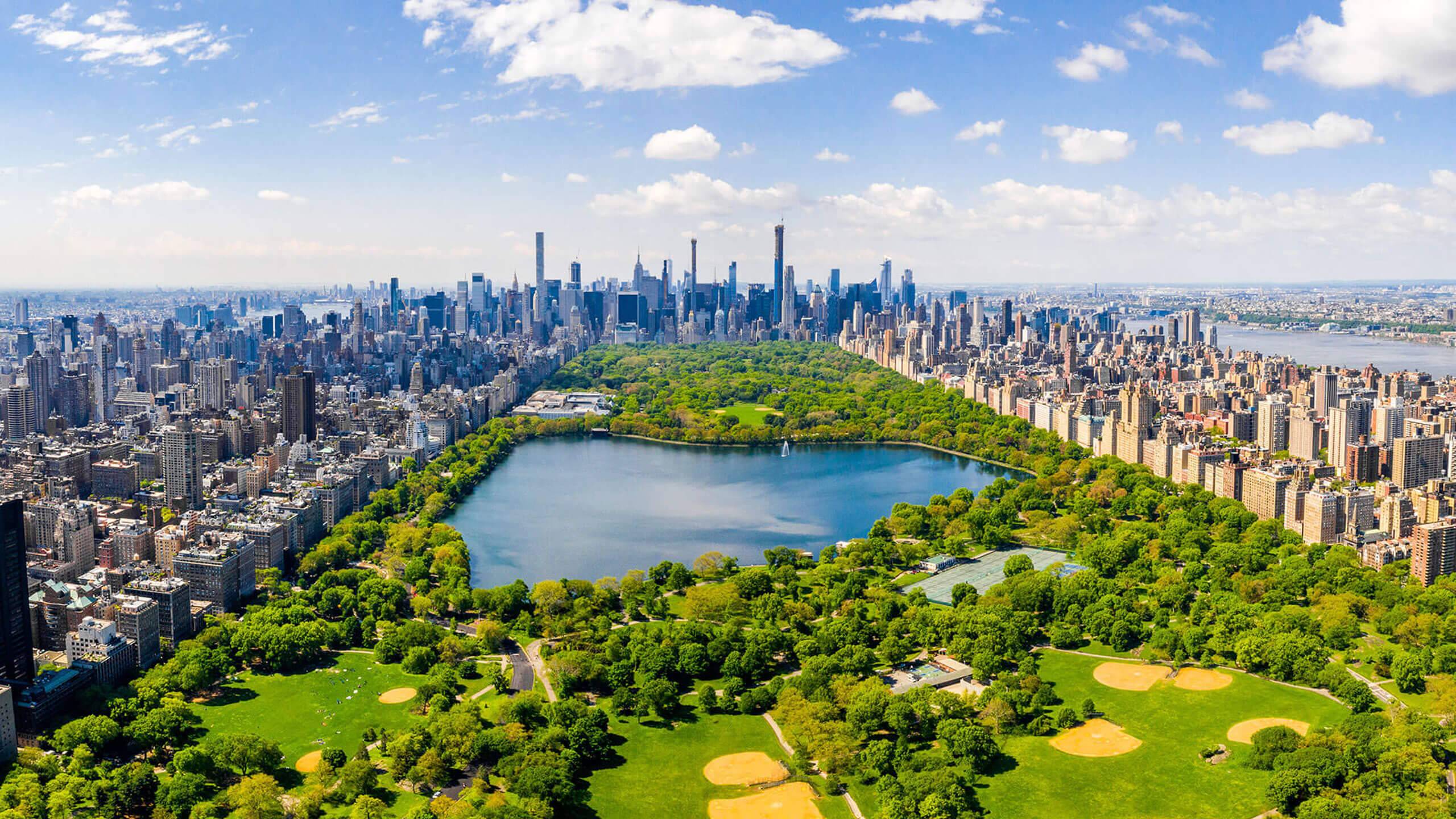 Stadt mit See und Skyline im Hintergrund, harmonische Verbindung von Natur und Urbanität.